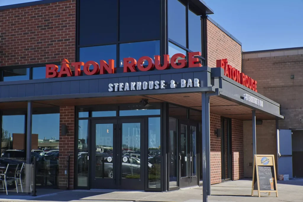 Exterior view of a Baton Rouge Steakhouse & Bar location, showcasing the restaurant's signage. The image highlights the inviting atmosphere of one of MTY Group's successful Canadian franchises. | The Strategy Behind Selling Happiness with a Thriving Franchise: A Conversation with MTY's CEO Blog