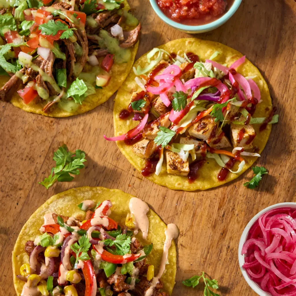 Mucho Burrito tacos with fresh, vibrant toppings including cilantro, salsa, and chargrilled ingredients showcasing customizable Mexican cuisine.